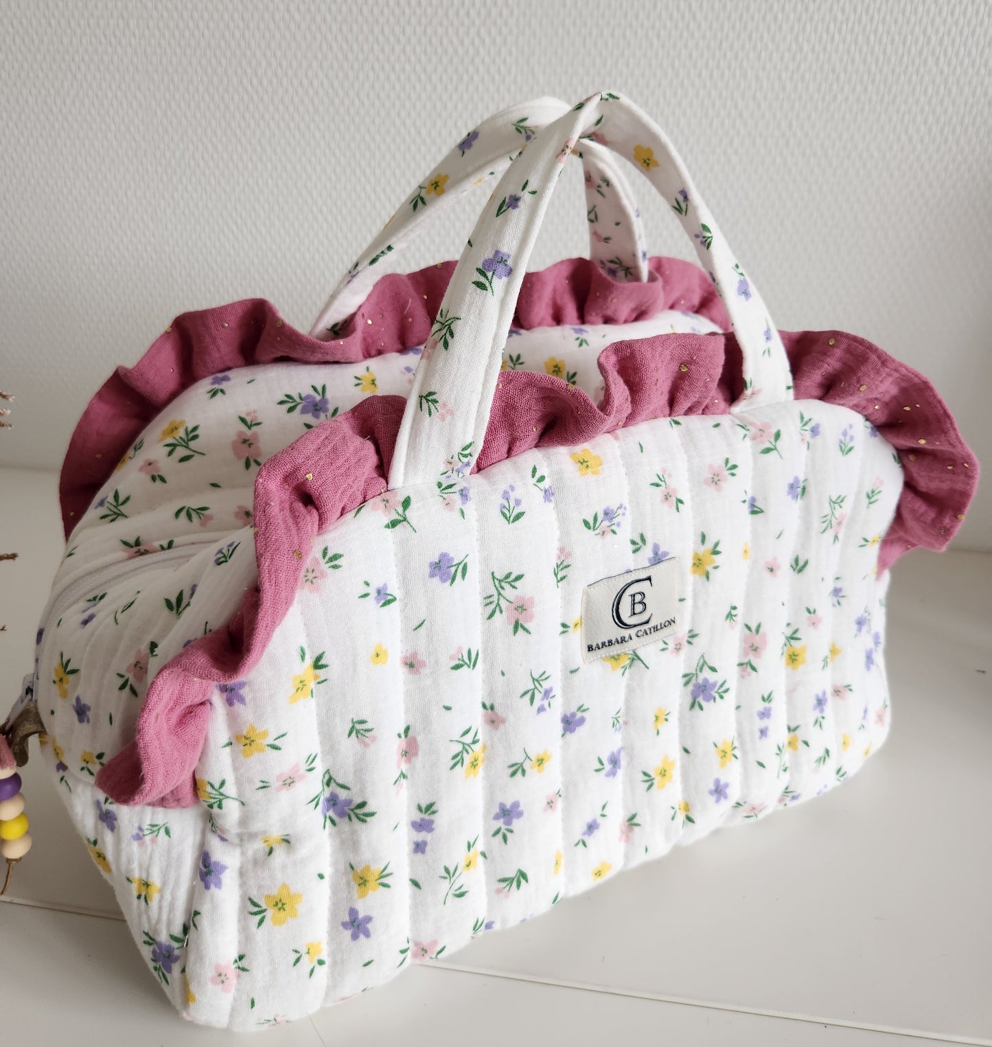Valisette gaze de coton fleurie matelassée et volants rose.