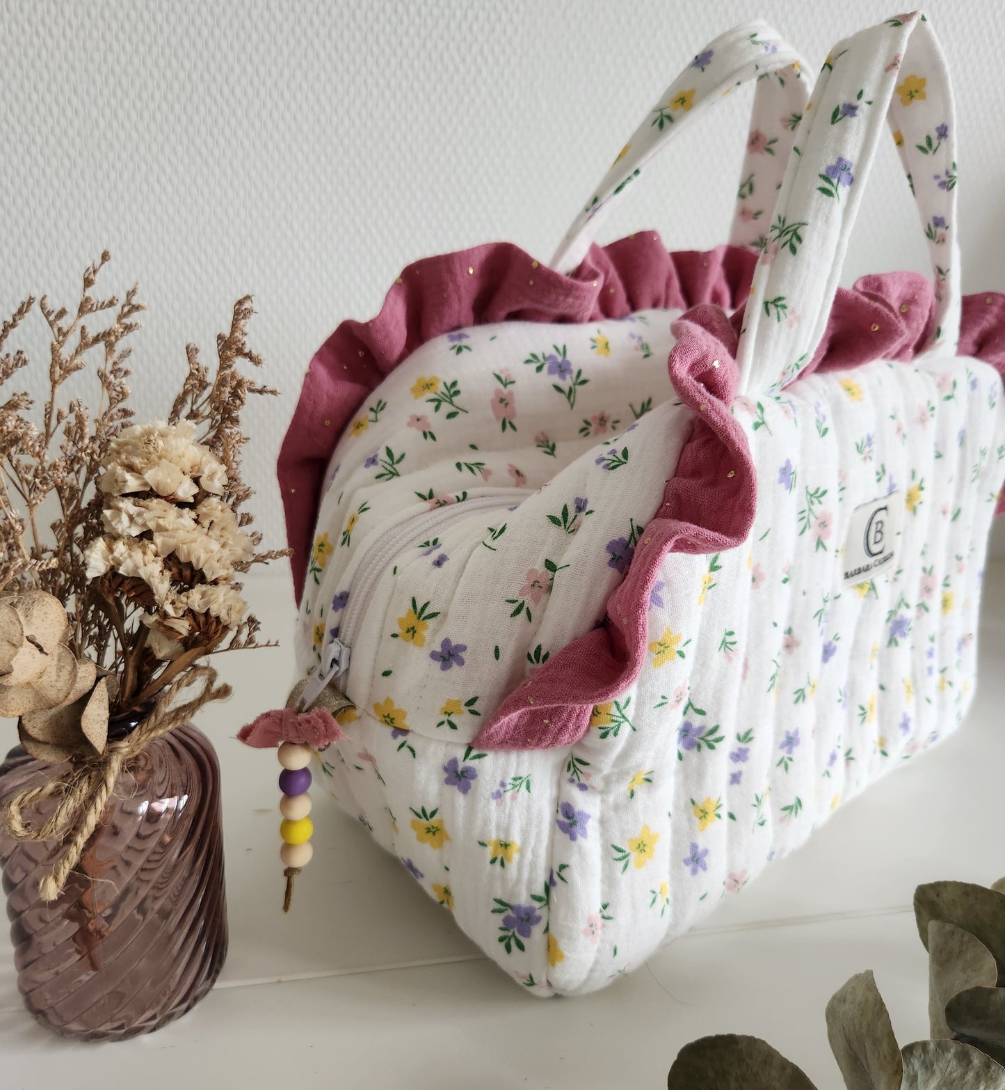 Valisette gaze de coton fleurie matelassée et volants rose.