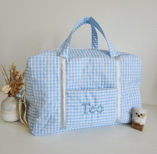 Wickel- oder Reisetasche aus hellblauer Gingham-Baumwolle.